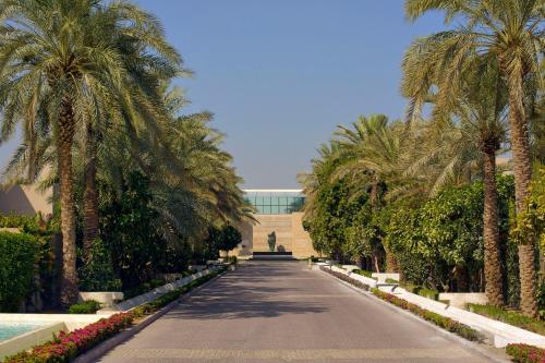 迪拜Meliá Desert Palm Member of Meliá Collection的一条棕榈树和一座建筑连成一条公路