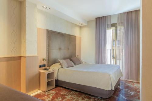 巴塞罗那哥特酒店的一间卧室设有一张床和一个窗口
