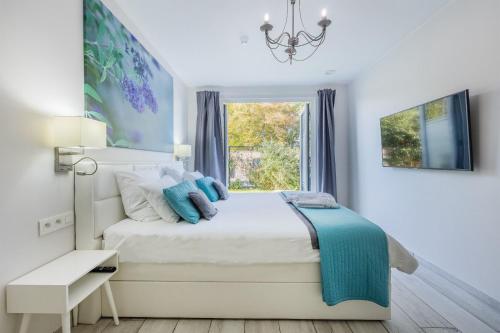 赫拉尔兹贝亨Vakantievilla - B&B Blue Garden Vlaamse Ardennen的白色的卧室设有床和窗户