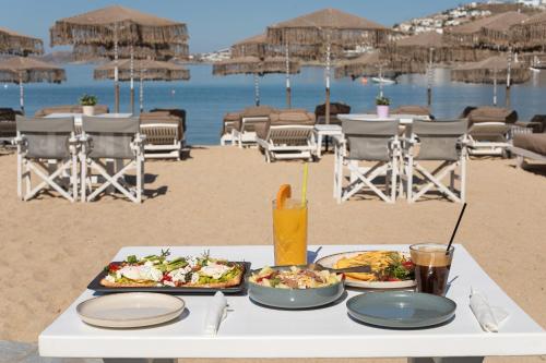 帕瑞加Agia Anna Beachfront Boutique的海滩上一张桌子,上面放着两盘食物