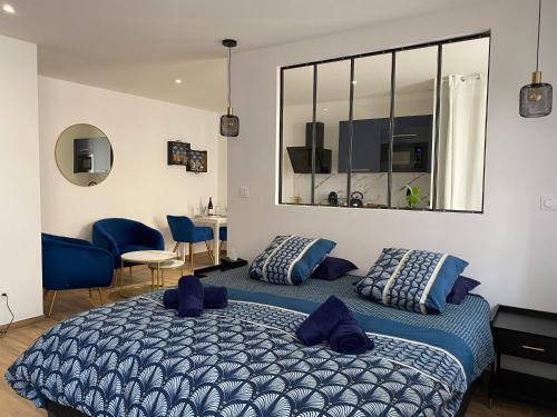 Cosy Appart’ & spa - Appartement privatif - baignoire balnéothérapie的一间卧室配有一张带蓝色枕头的大床