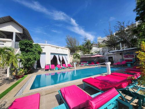 美奈美奈山背包客旅舍的一个带粉红色躺椅的游泳池和一个游泳池