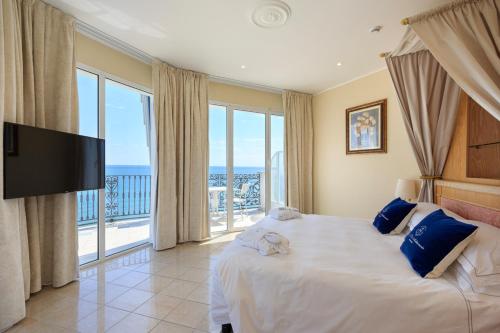 阿拉西奥美帝特拉奈大酒店的一间卧室设有一张带电视的床和一个阳台。
