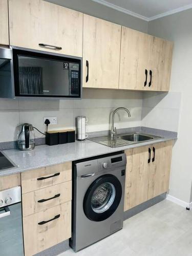 哈博罗内Motswedi 1 bedroom apartment B9的厨房配有洗衣机和水槽