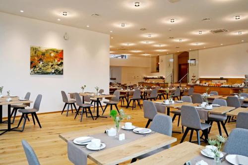弗赖因斯海姆Landhotel Altes Wasserwerk GbR的用餐室配有木桌和椅子