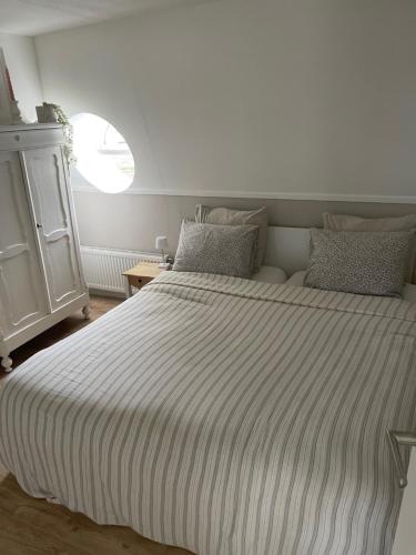 莱顿Veldhorst Apartments的一间卧室配有一张带条纹毯子的大床