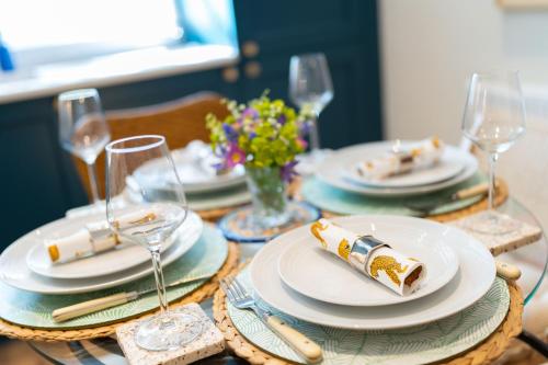 邓迪Binrock Lodge的桌子上放有盘子和玻璃杯,上面放着食物