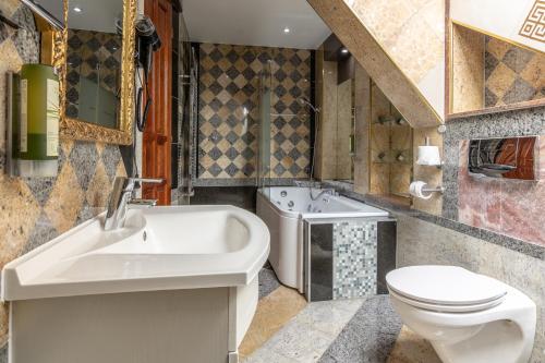 格拉茨Best Western Hotel Strasser的浴室配有盥洗盆、卫生间和浴缸。