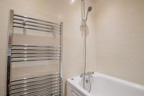 伦敦Guest Homes - Lewisham Flat的带淋浴和浴缸的浴室