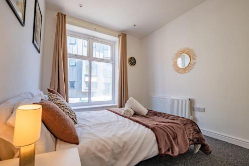 伦敦Guest Homes - Lewisham Flat的一间卧室设有一张大床和一个窗户。
