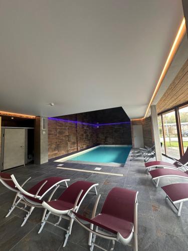 Les Hôpitaux-NeufsRésidence Le Sommet的一个带椅子的游泳池和一个游泳池