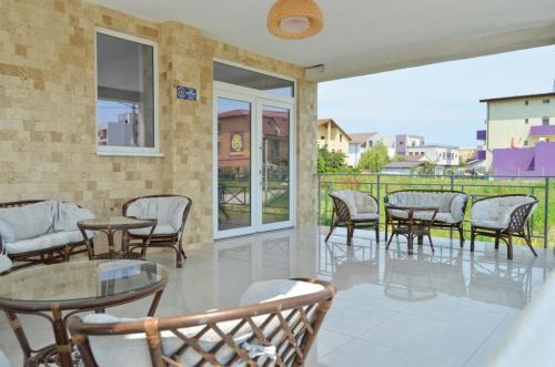 北马马亚-讷沃达里Abi Mykonos的一个带桌椅的庭院和一个阳台