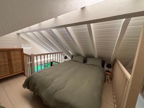 NancesChalet les pieds dans l'eau Lac Aiguebelette的卧室内的一张床位,拥有白色的天花板