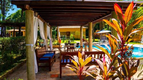 博多克纳Recanto 3ELLL的一个带椅子和遮阳伞的庭院和一个游泳池
