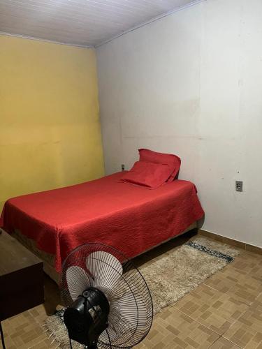 吉巴拉那Apt Rondônia rual show的卧室配有红色的床和风扇
