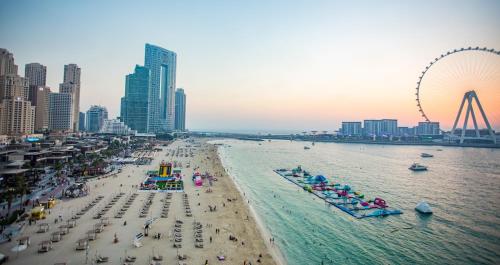 迪拜The W Jumeirah Beach的一群人和一辆过山车的海滩