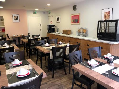莫达讷乐科迈司酒店的餐厅设有木桌、椅子和柜台