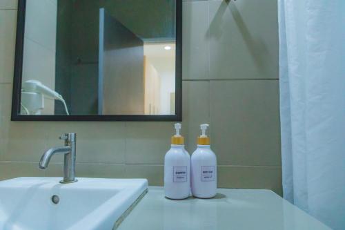 卡宾布里Uou Hotel的浴室内水槽上的两瓶水