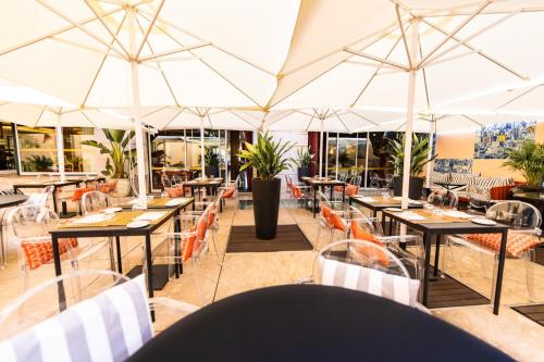 里斯本里尔酒店的空餐厅,配有桌子和遮阳伞