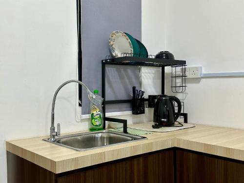 北赖Dreamy Cozy Studio Meritus Residensi Perai的厨房柜台设有水槽和微波炉