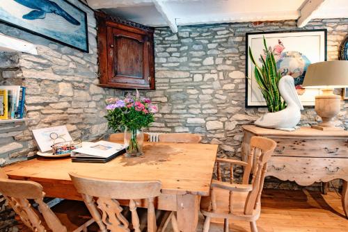 斯沃尼奇Cosy Little Hyde Cottage, Swanage的一间带木桌和椅子的用餐室
