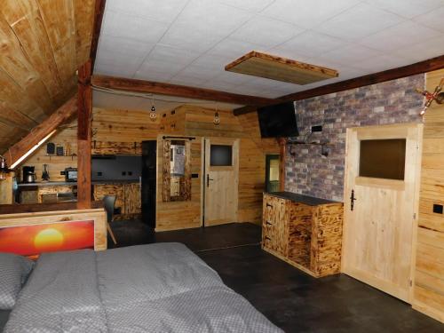 PloddaHaus Feierabend的卧室配有一张床铺,位于带木墙的房间内