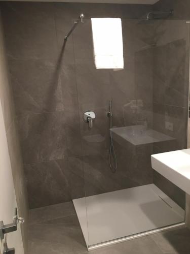 加尔达湖滨玛丽娜公寓式酒店的一间带玻璃淋浴间和水槽的浴室
