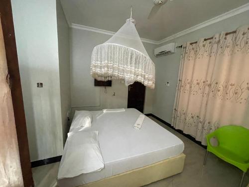 达累斯萨拉姆Konokono Mbezi beach的卧室配有白色的床和吊灯。