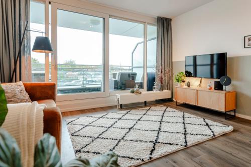 WarmondKaag Resort的带沙发和大窗户的客厅