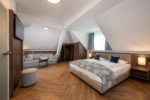 萨尔茨堡Salzburg Hotel Lilienhof的一间卧室配有一张大床和一张沙发