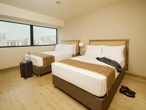 利马埃斯特拉贝拉维斯塔公寓式酒店的酒店客房设有两张床和窗户。