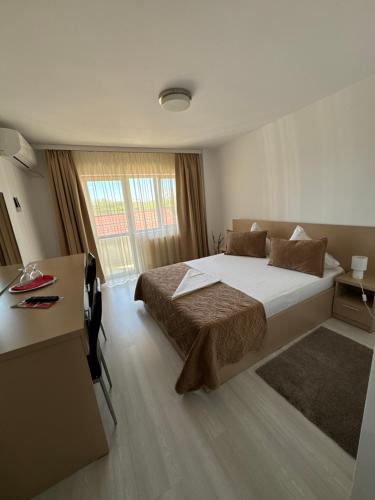 奥托佩尼FAST Airport Accomodation的一间卧室配有一张大床、一张桌子和一个窗户。