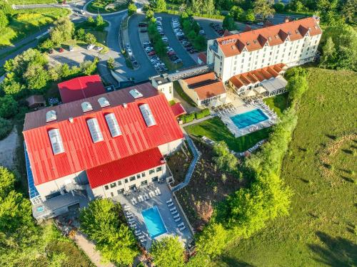 耶拿FAIR RESORT All Inclusive Wellness & Spa Hotel Jena的享有红色屋顶的大房子的空中景色