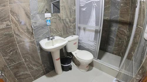 GuamoteHostal Flor de los Ángeles的浴室配有卫生间、盥洗盆和淋浴。
