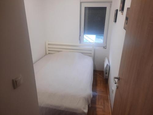 SurčinLeo的一间小卧室,配有白色的床和窗户