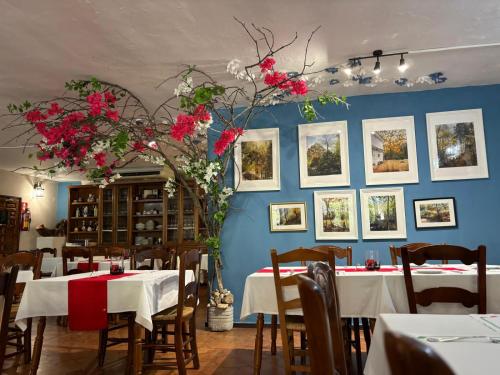 奥亨Hotel El Refugio de Juanar的墙上设有餐桌和鲜花的用餐室
