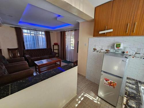 KaruriImmaculate 3 bedroom House in Ndenderu near Ruaka的带冰箱的厨房和客厅