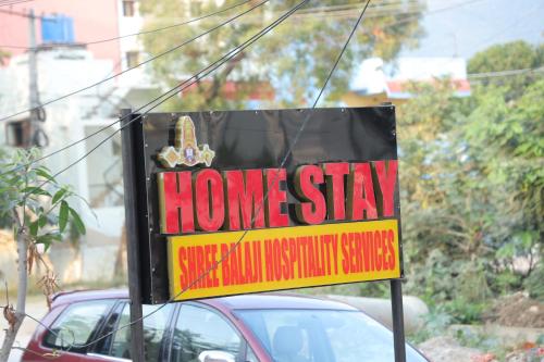 蒂鲁帕蒂SBHS Neeladri Homestay的汽车前的居家住宿标志