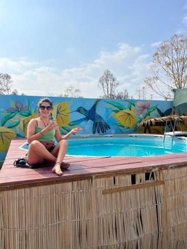 帕拉卡斯Paracas Camp Lodge & Experiences的坐在游泳池边缘的女人