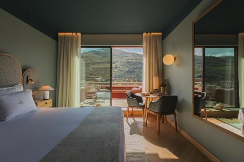 比索达雷加Torel Quinta da Vacaria - Douro Valley的一间卧室配有一张床和一张桌子及椅子