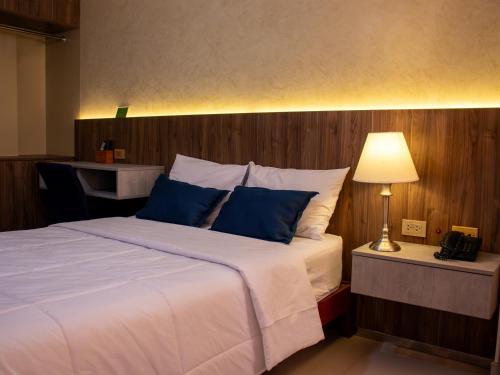 齐克拉约Hotel America Chiclayo的一间卧室配有一张带蓝色枕头的大床