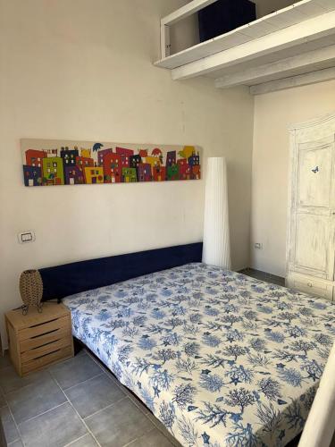 巴科利La Casa di Baia的卧室配有一张床,墙上挂有绘画作品