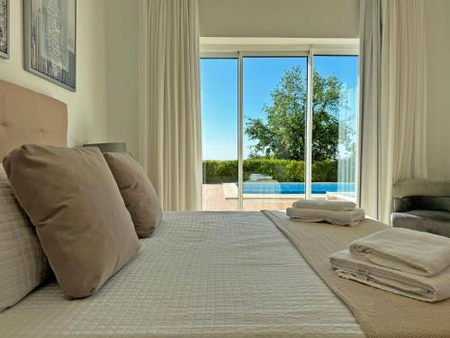 阿尔科斯-德拉弗龙特拉Villa Los Olivos - Ole Solutions的一间卧室设有一张床,享有游泳池的景色