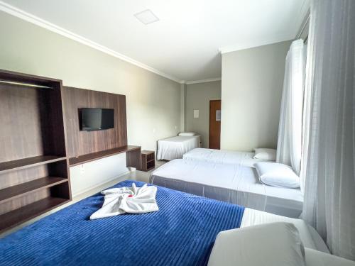 阿尔塔米拉Dallas Hotel Premium的酒店客房 - 带两张床和床上的毛巾