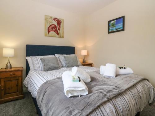 邓迪Rehoboth Lodge的一间卧室配有一张带两条白色毛巾的床