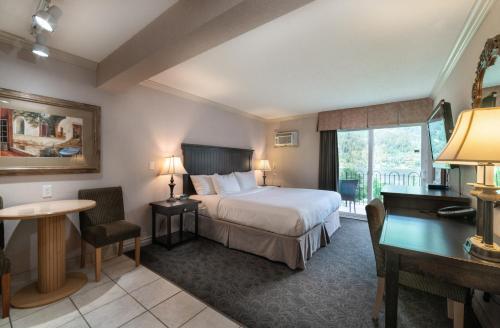 尼尔逊尼尔森威望酒店的配有一张床和一张书桌的酒店客房