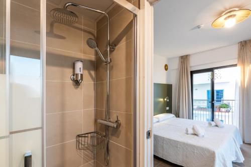 圣安东尼奥阿利坎特旅舍的带淋浴的浴室和客房内的一张床