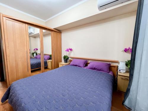 阿拉木图Золотой квадрат 60 кв2的一间卧室配有一张紫色的床和镜子