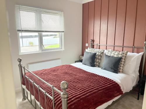 基督城Serenity Lodge, Riverside with Free Parking的一间卧室配有一张红色床头板的床