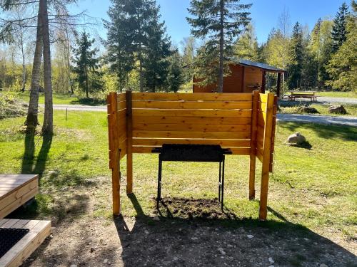 NõvaMarika Puhkeküla - Metsanurga Öömaja的坐在公园草地上的木凳